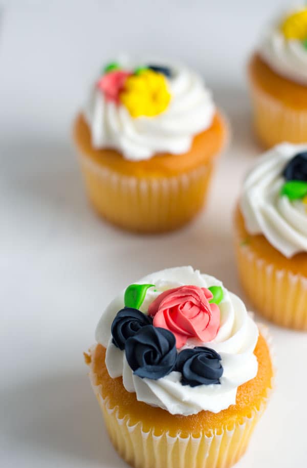 These simple royal icing flowers make great decorations for cakes, cupcakes, and cookies and are perfect for spring!