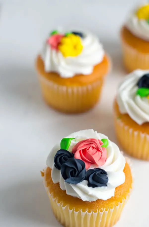These simple royal icing flowers make great decorations for cakes, cupcakes, and cookies and are perfect for spring!