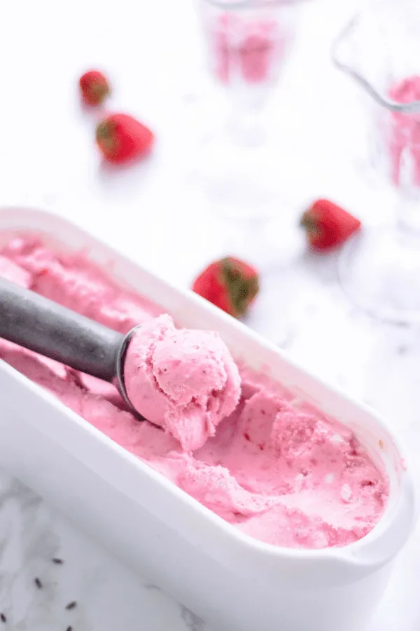 This homemade strawberry ice cream is creamy, dreamy, and made with fresh strawberries and lavender blossoms. Looking for a healthy ice cream recipe for a sweet summer treat? Try churning this! It doesn’t take much to learn how to make homemade ice cream. You can also switch out strawberries with blueberries based on your preference. #homemade #summerdessert #icecream #lavender #strawberry