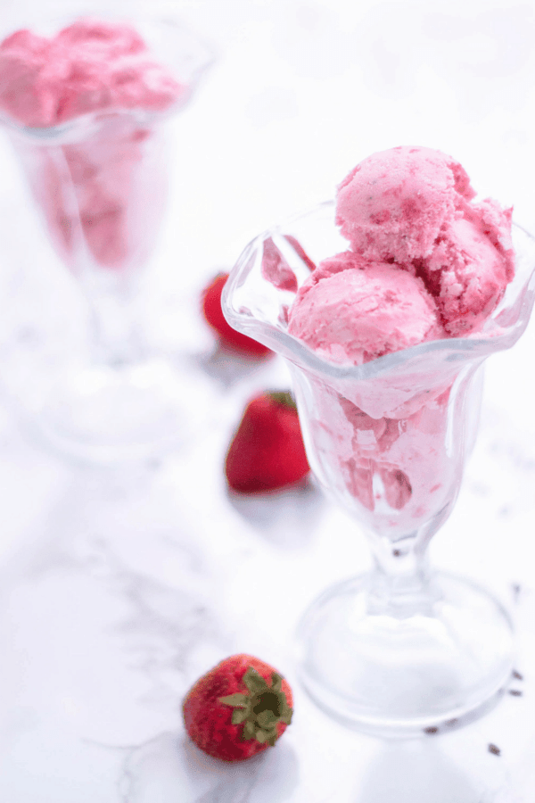 This homemade strawberry ice cream is creamy, dreamy, and made with fresh strawberries and lavender blossoms. Looking for a healthy ice cream recipe for a sweet summer treat? Try churning this! It doesn’t take much to learn how to make homemade ice cream. You can also switch out strawberries with blueberries based on your preference. #homemade #summerdessert #icecream #lavender #strawberry