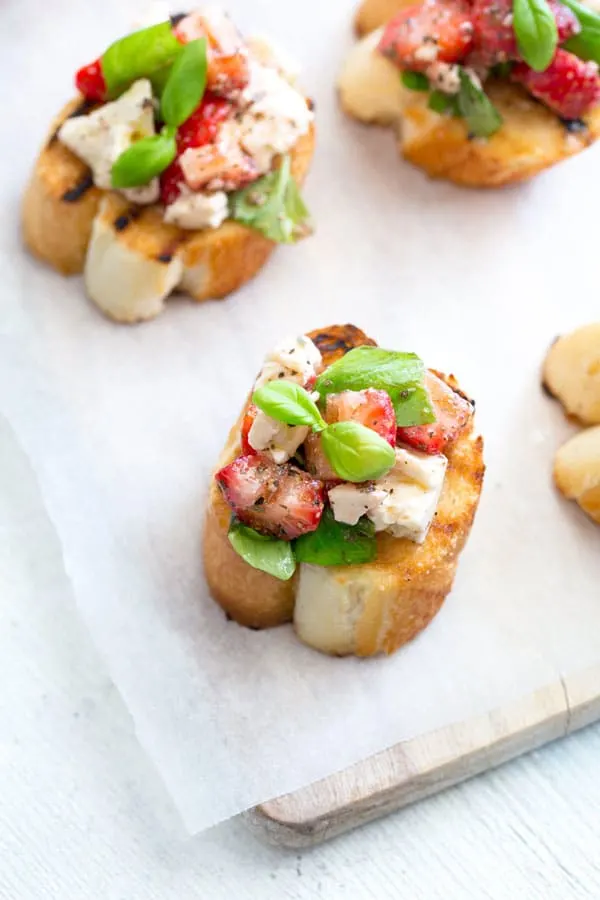 I’m so excited to have Claire from Sprinkles and Sprouts here sharing her amazing Strawberry and Feta Bruschetta! It’s the perfect summer appetizer for a crowd! Sweet strawberries and salty feta, on crisp crostini. Serve this for brunch or a summer lunch party. #appetizers #summerlunch #brushetta #appetizerrecipes #strawberries