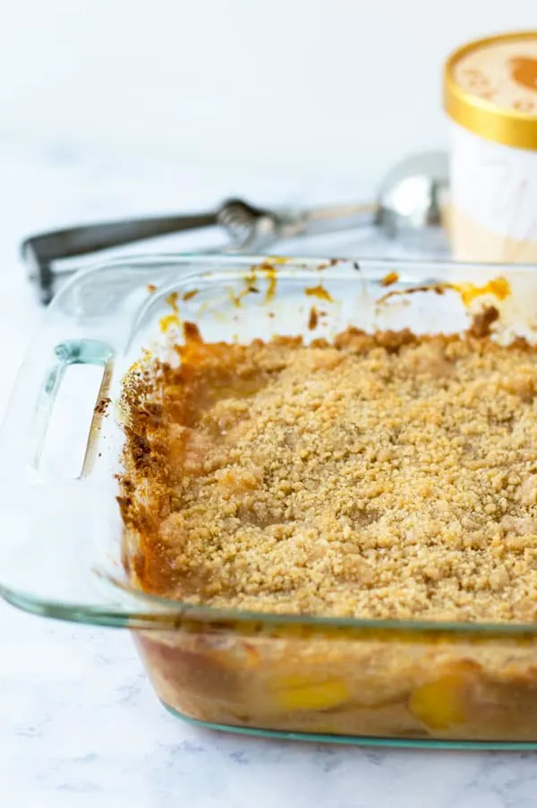 This easy peach crumble pie is a great end of summer treat.  Peaches smothered in caramel sauce and topped with a crunchy brown sugar crumble make for a perfectly decadent summer dessert.