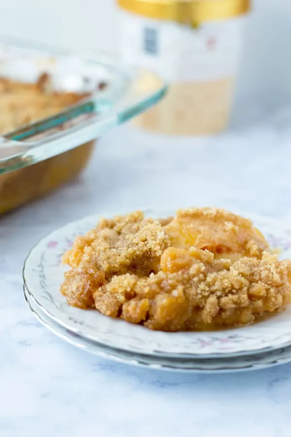 This easy peach crumble pie is a great end of summer treat.  Peaches smothered in caramel sauce and topped with a crunchy brown sugar crumble make for a perfectly decadent summer dessert.